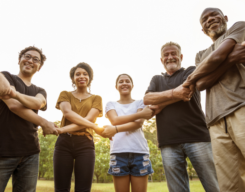 group of people holding hands with arms crossed